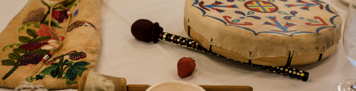 Indigenous artifacts and food, including drum, strawberry and beaded bag